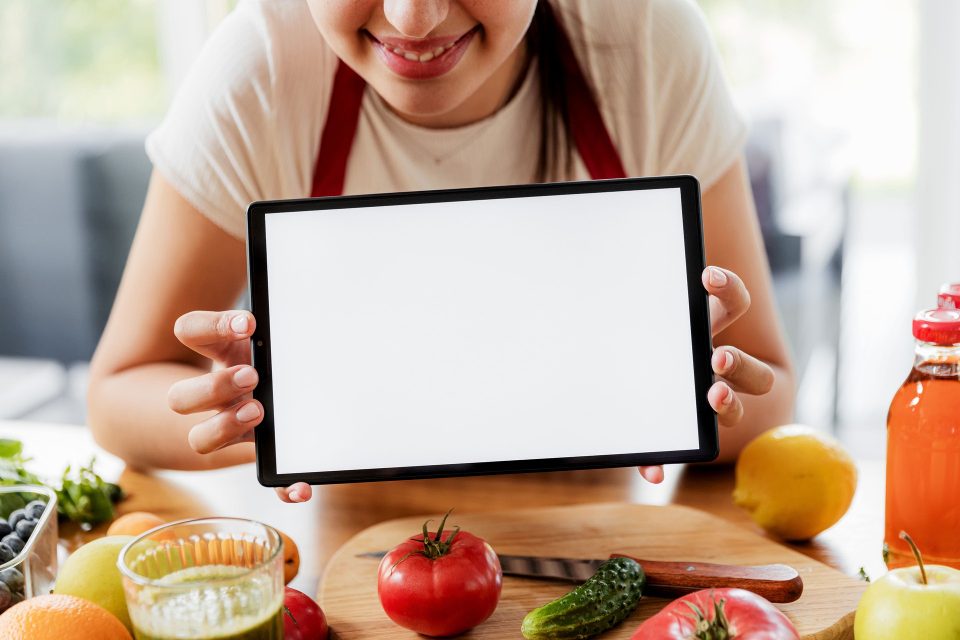 Woman hands at kitchen showing tablet with empty blank screen mockup